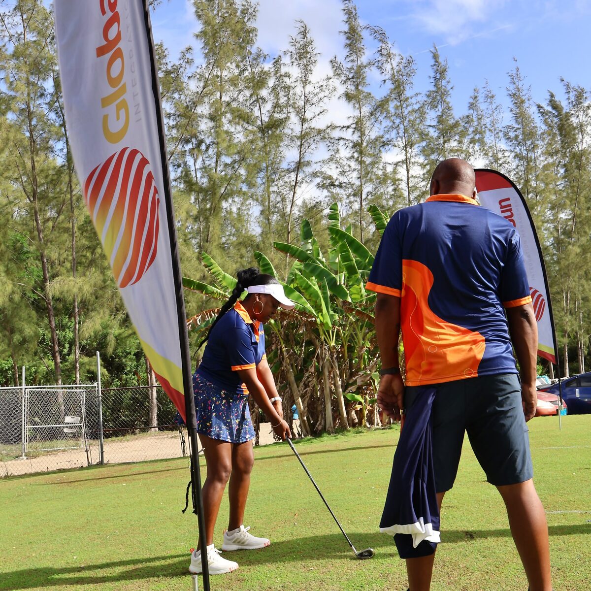 A Global Sun Integration player tees off beside the company banner