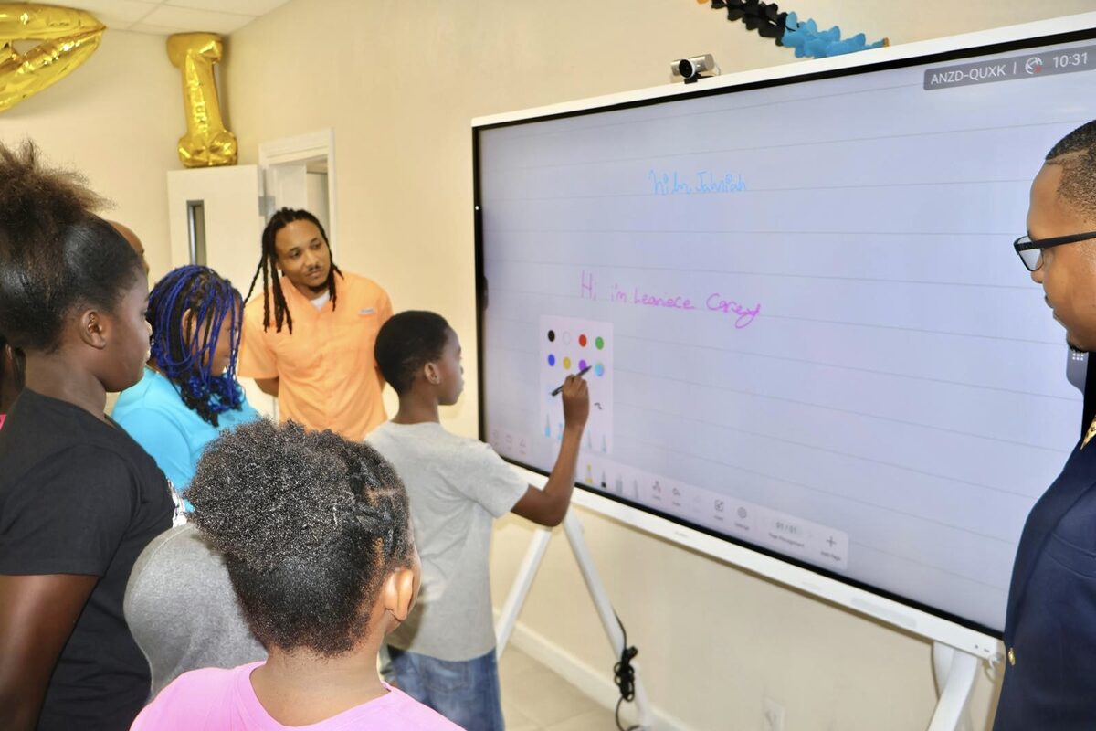 A student writes on the new interactive touchscreen board at the Nassau Village Community Centre