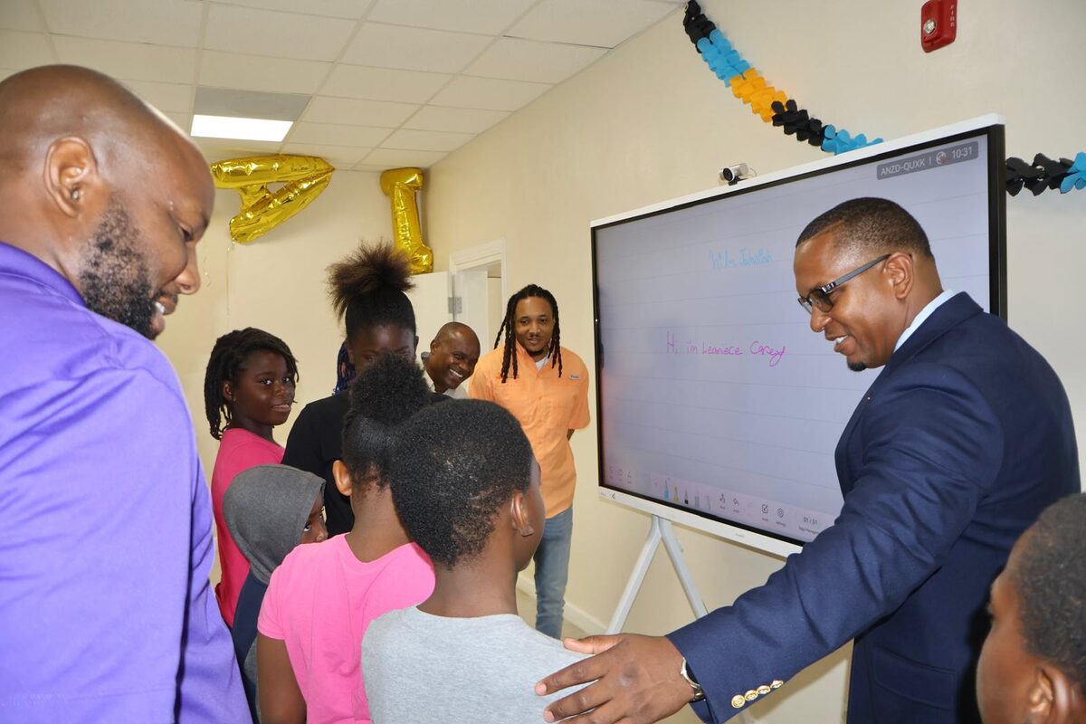 MP Jamahl Strachan with students gathered around the interactive board